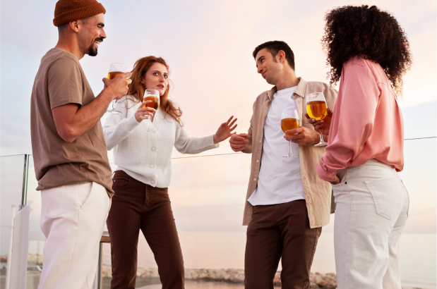 Friends enjoying drinks on a rooftop terrace with city view