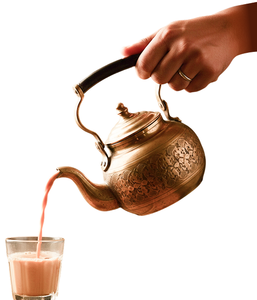 Hand pouring tea from kettle into glass